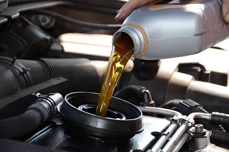 Fresh motor oil being poured during an oil change service at Beach Auto Repair